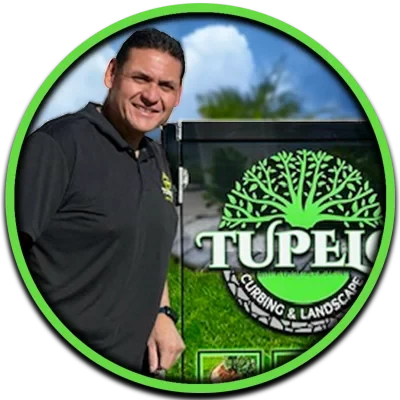 Jose Cedillo beside the Tupelo Curbing & Landscape sign