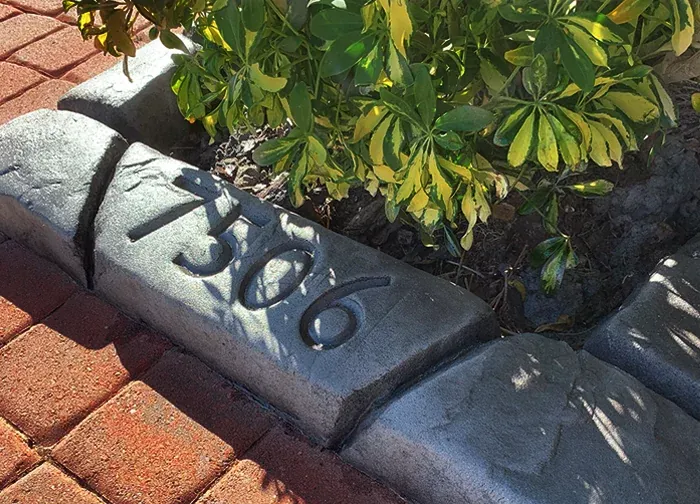 House number imprinted into a curb