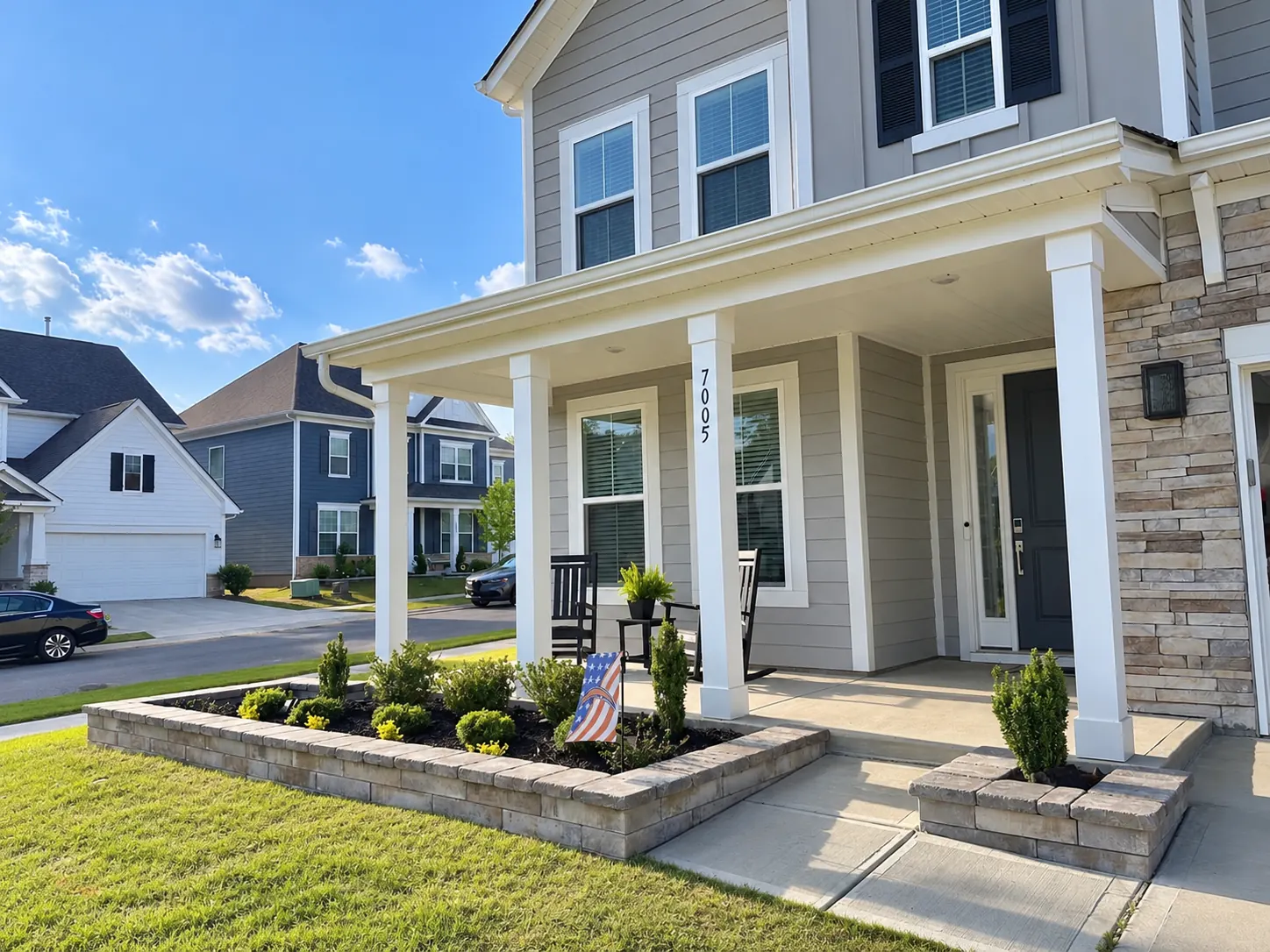 Front porch with white columns and a low planted bed