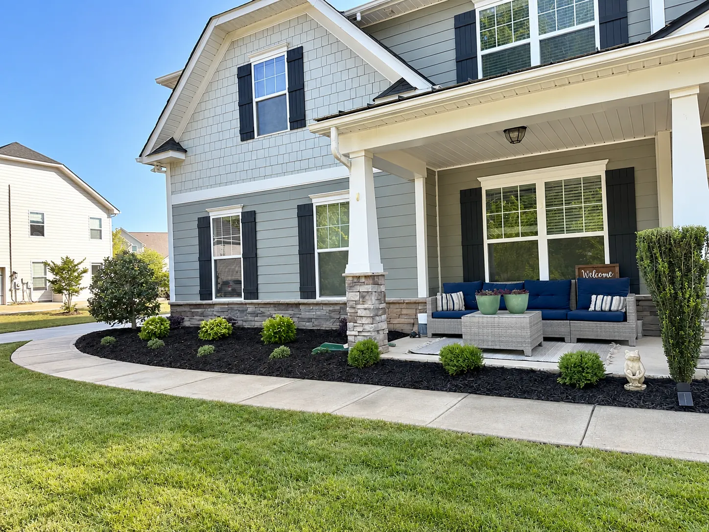 Front porch with outdoor seating, a dark mulched bed and a curved walk